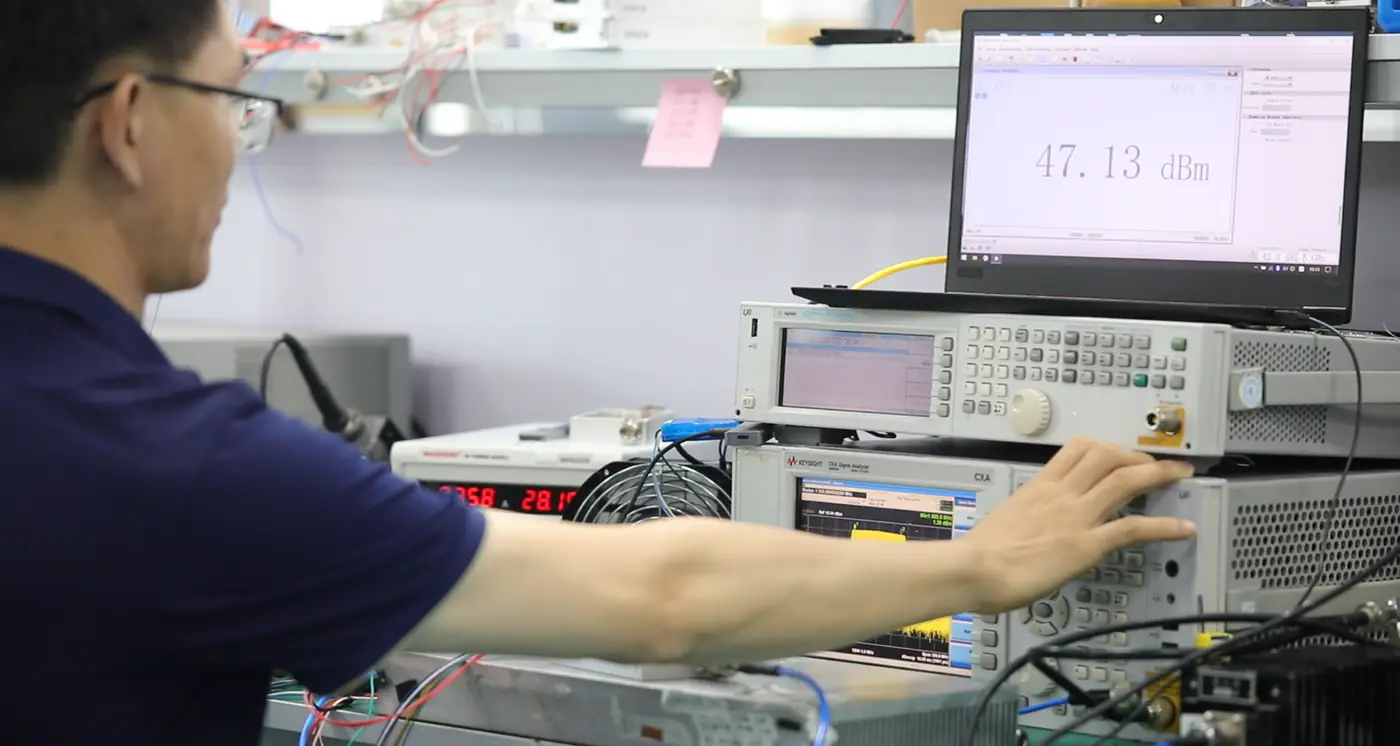 Tecnico che controlla un modulo RF con strumenti di prova